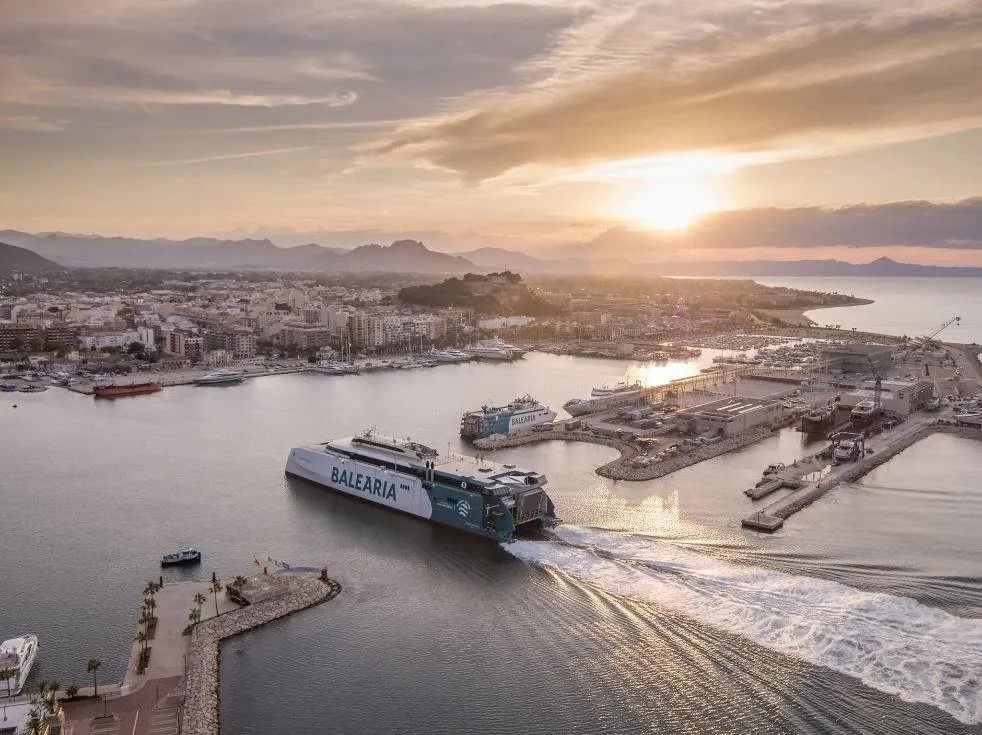 De veerboot vaart bij zonsondergang de haven van Dénia uit