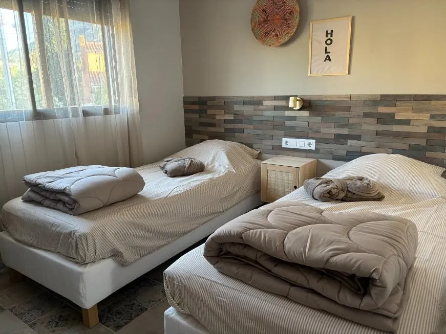 Derde slaapkamer met twee eenpersoonsbedden en HOLA-wanddecoratie