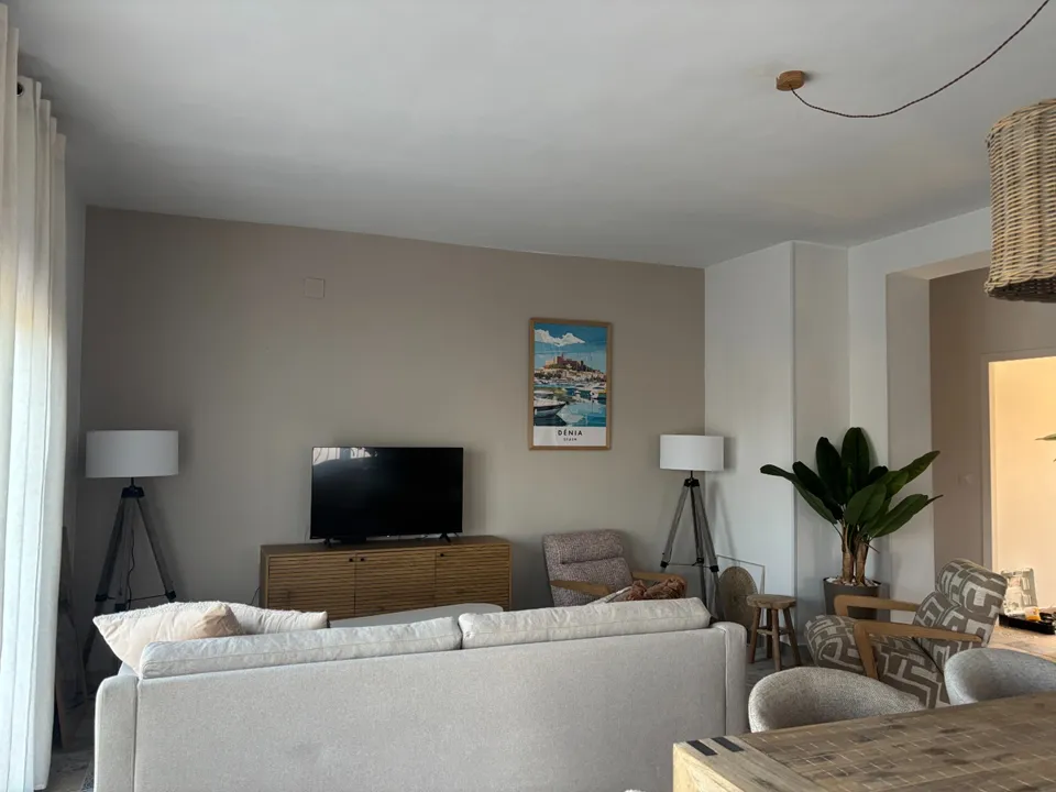 Lichte woonkamer met loungebank, smart TV en eethoek in Appartement Boven